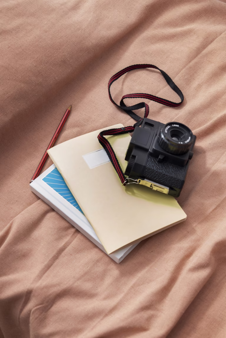 Appareil photo et carnet, vue en plongée